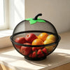 A black metal fruit basket with a green mesh cover filled with various fresh fruits.