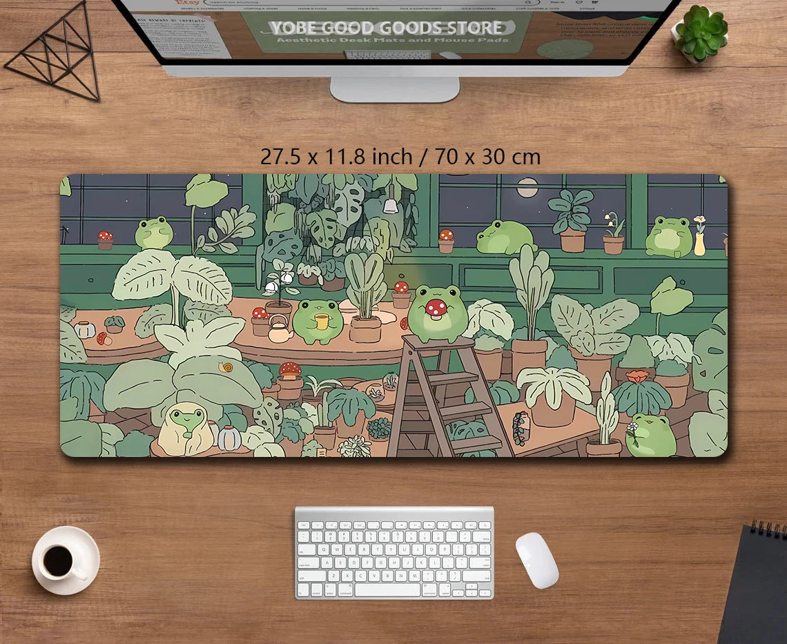 A large extended desk mat featuring a kawaii nature design of various green frogs and potted plants.