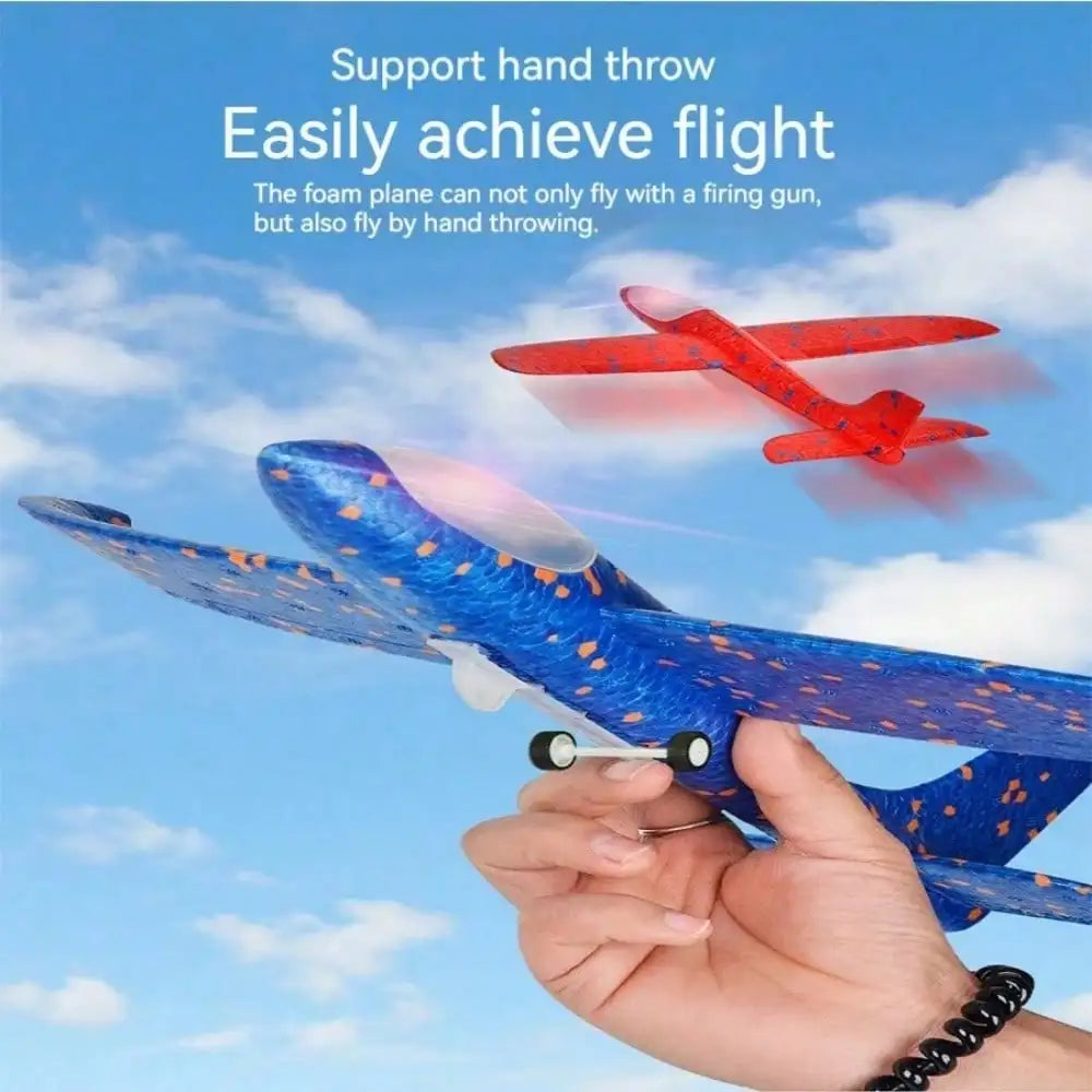 A hand holds a blue and orange foam plane glider flying in the sky against a cloudy blue background.