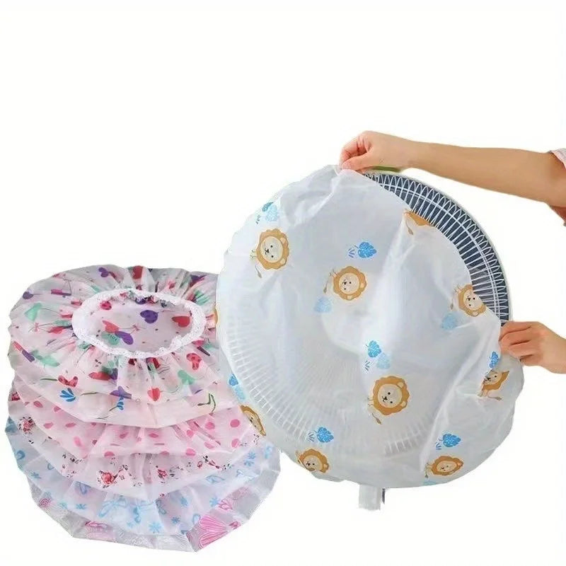 A white dust cover for electric fans is being held by a hand, showing decorative floral patterns.