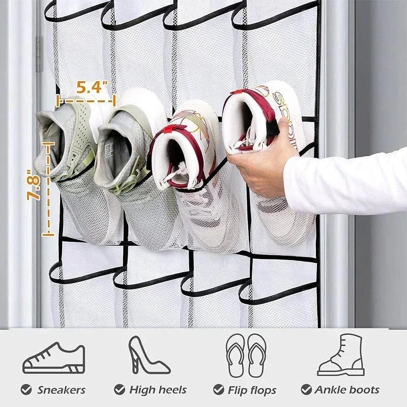A hand is hanging various athletic shoes, including sneakers and ankle boots, in a white over-the-door mesh shoe organizer.