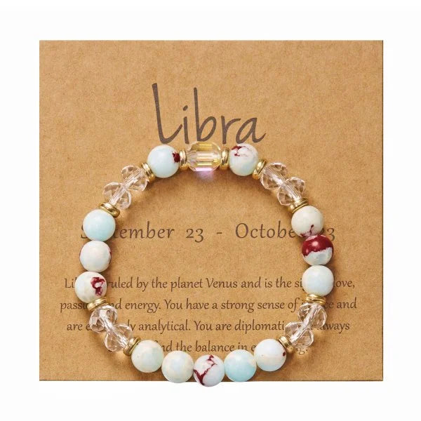 Perlenarmband mit hellblauen und weißen Kristallen, präsentiert auf einer braunen Karte mit Libra-Widder-Informationen.