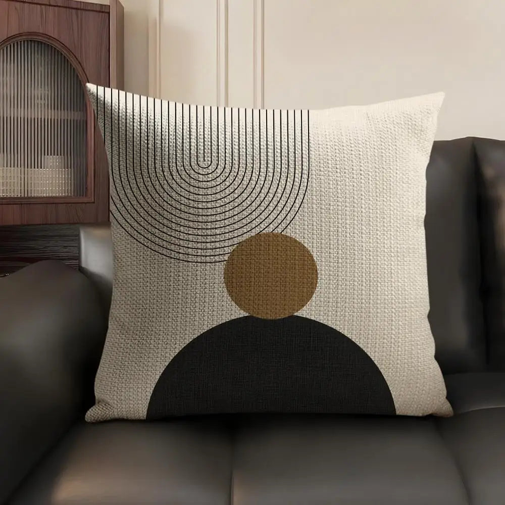 A beige linen cushion cover featuring black geometric lines and a large brown circle on a dark background.