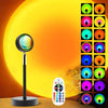 A sunset lamp projector with a lens and remote control displaying 16 color modes against an orange background.