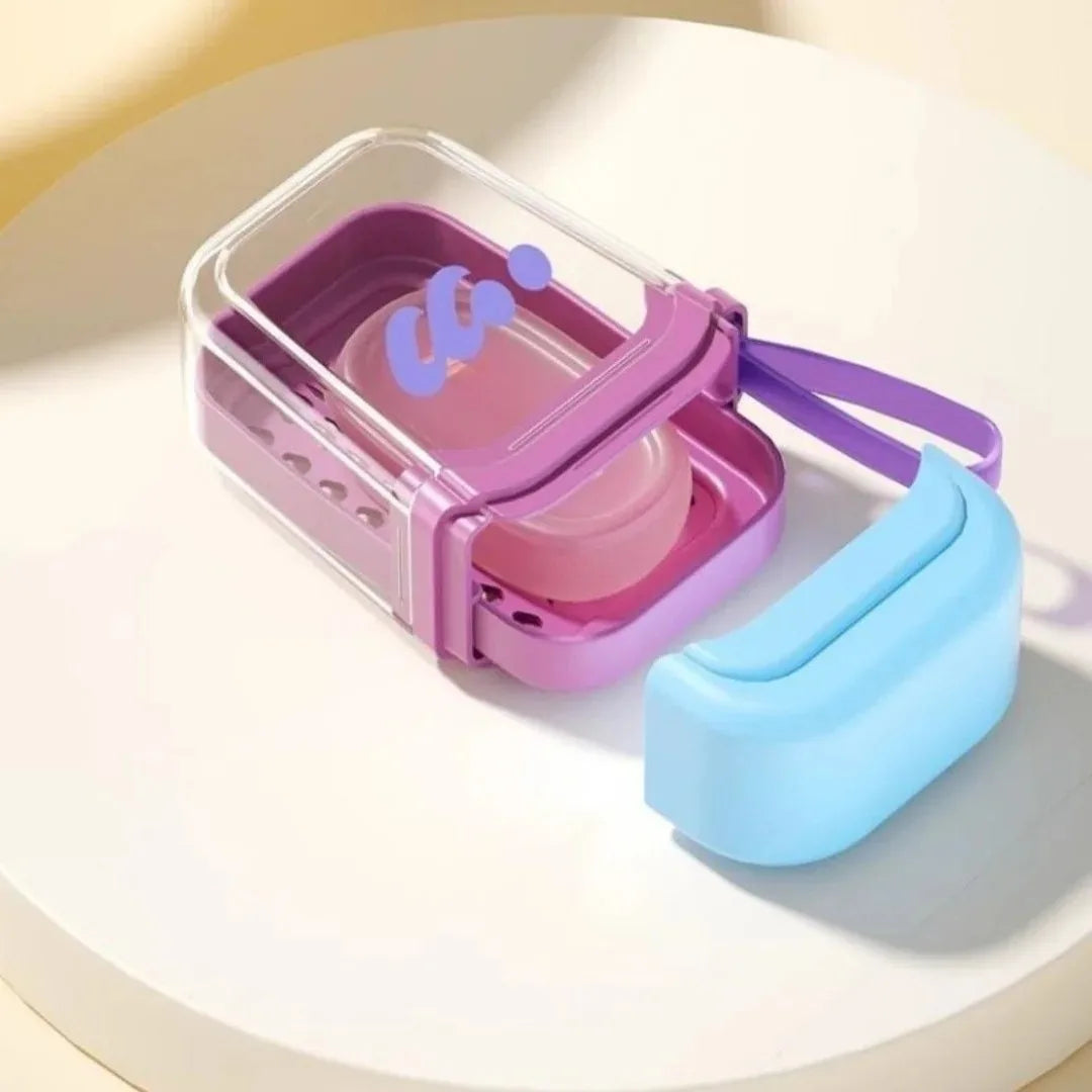 A purple leakproof travel soap case with a secure lid and a light blue silicone soap dispenser is shown on a white surface.