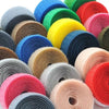 A collection of colorful sew-on hook and loop tape strips in various shades of blue, green, yellow, orange, and pink.