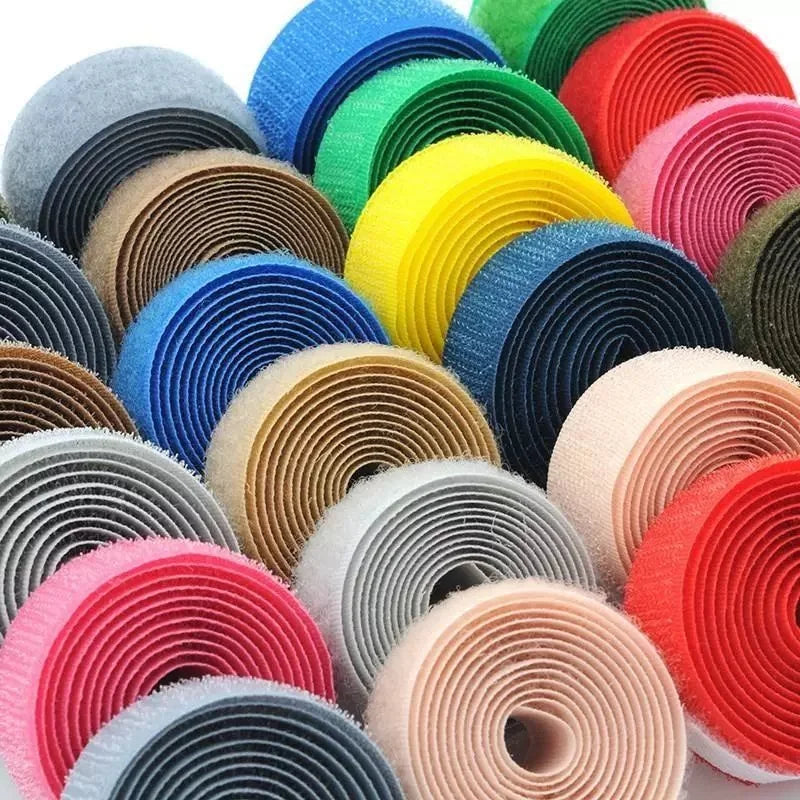 A collection of colorful sew-on hook and loop tape strips in various shades of blue, green, yellow, orange, and pink.