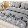 Gray duvet cover set with butterfly print and matching pillowcases displayed on a bed.