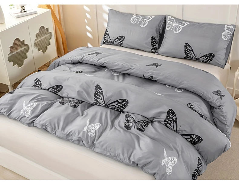 Gray duvet cover set with butterfly print and matching pillowcases displayed on a bed.