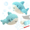 A light blue crocheted sea turtle toy and yarn with a needle shown next to bubbles.