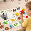 A young child is playing a letter matching game using wooden cards and alphabet blocks on a table.
