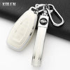 Silver silicone car key fob cover with a black emblem attached to a metal keyring.
