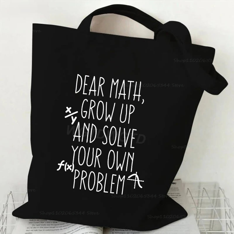 Black canvas tote bag with white text that reads Dear Math Grow Up and Solve Your Own Problem