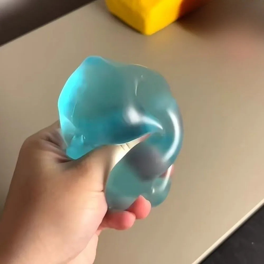 A hand is holding a translucent blue stress ball with a purple tint against a light background.