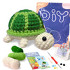 A finished green and white crocheted turtle toy next to yarn, needles, and a DIY craft bag.