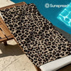 A classic leopard print quick-dry microfiber towel displayed on a wooden rack.