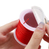 A hand holds a spool of red nylon macramé cord for jewelry making with a pink plastic container.