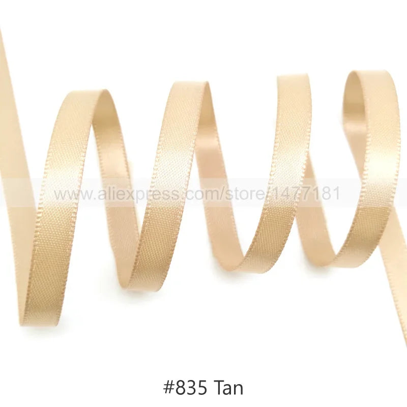 A roll of tan satin ribbon shown in a wavy line pattern.