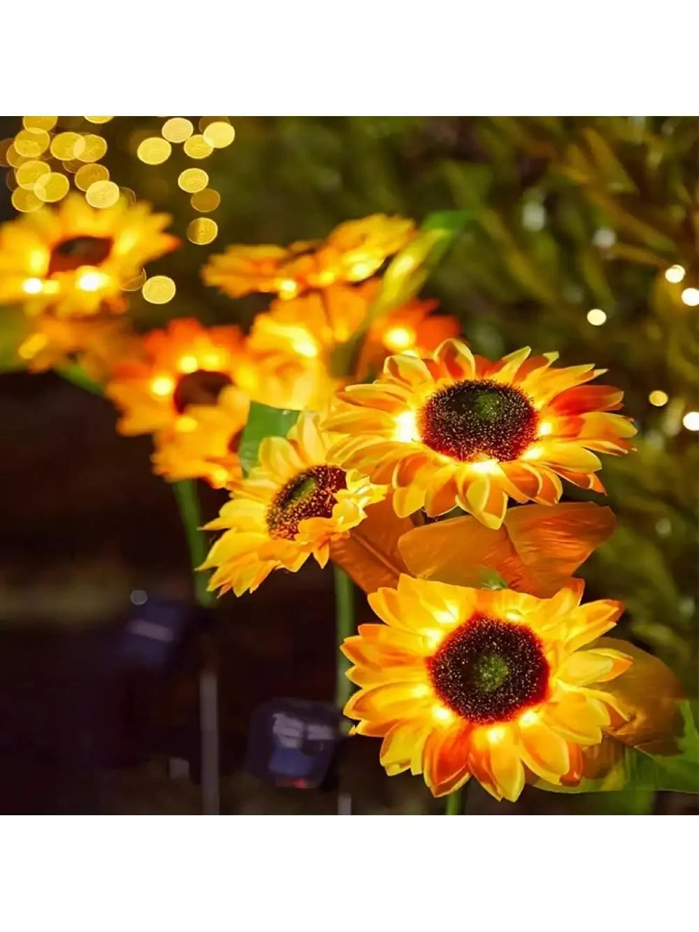 Close-up of bright orange solar-powered LED sunflower garden lights blooming in the dark.
