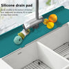 A silicone drain pad is installed at the bottom of a kitchen sink, protecting it from debris.