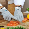 A pair of gray cut-resistant work gloves is shown holding orange salmon fillets on a wooden cutting board.