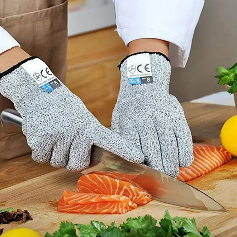 A pair of gray cut-resistant work gloves is shown holding orange salmon fillets on a wooden cutting board.
