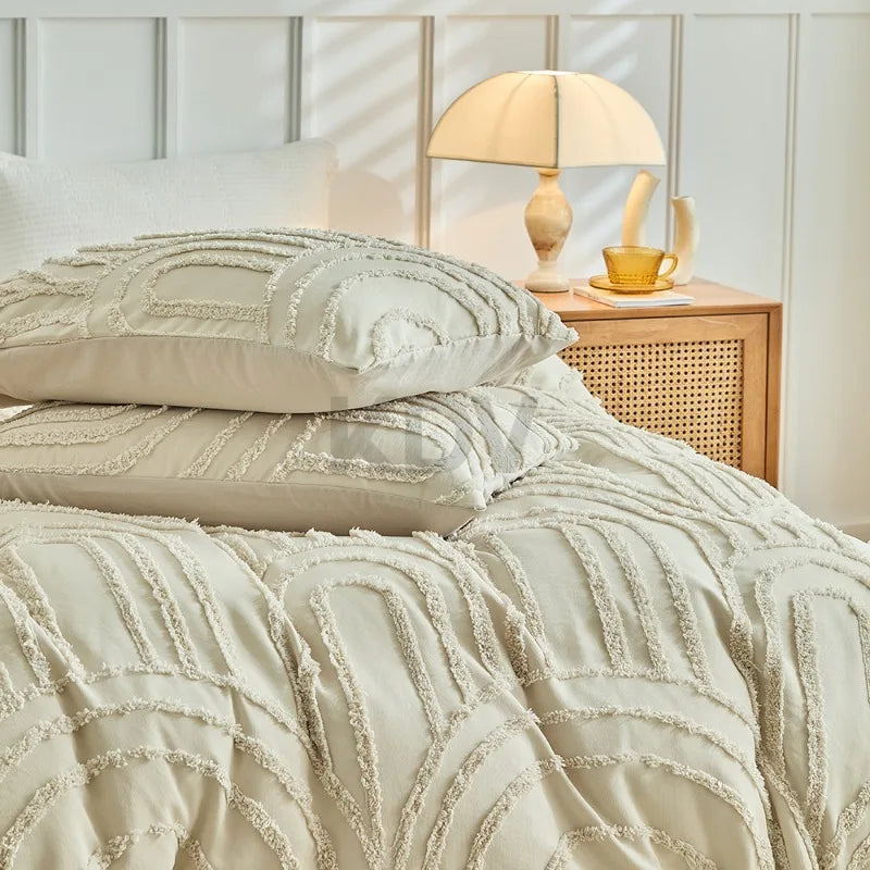 Beige, geprägte Blumen-Kopfteil-Duvetcover-Set auf einem Bett mit Lampe und goldenen Akzenten.