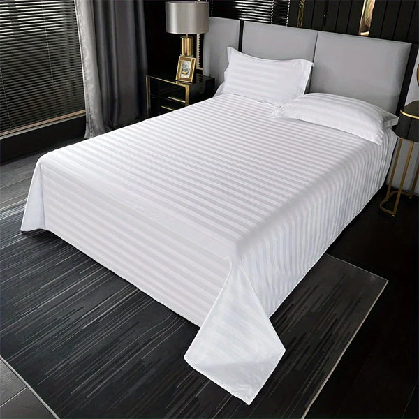 White striped cotton bed sheet set with white linens on a modern bed.