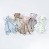 A collection of five stuffed animal baby comforters in various colors and floral patterns.