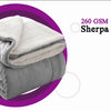 Manta gris sherpa doblada con forro de felpa blanca esponjosa, mostrada en un círculo morado.