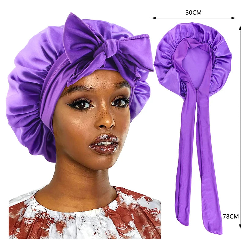Purple silky satin sleep cap with a wide bow band shown on a model's head and separate for display