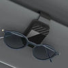 A pair of dark sunglasses resting in a magnetic glasses holder with a patterned grip.