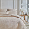A beige Nordic leaf print duvet cover set displayed on a bed with white molding and a bedside table.