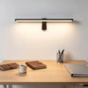 A modern light bar monitor light is mounted above a wooden desk, illuminating the workspace.