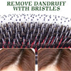 A close-up of a black hair brush with natural wood boar bristles used for detangling and scalp massage.