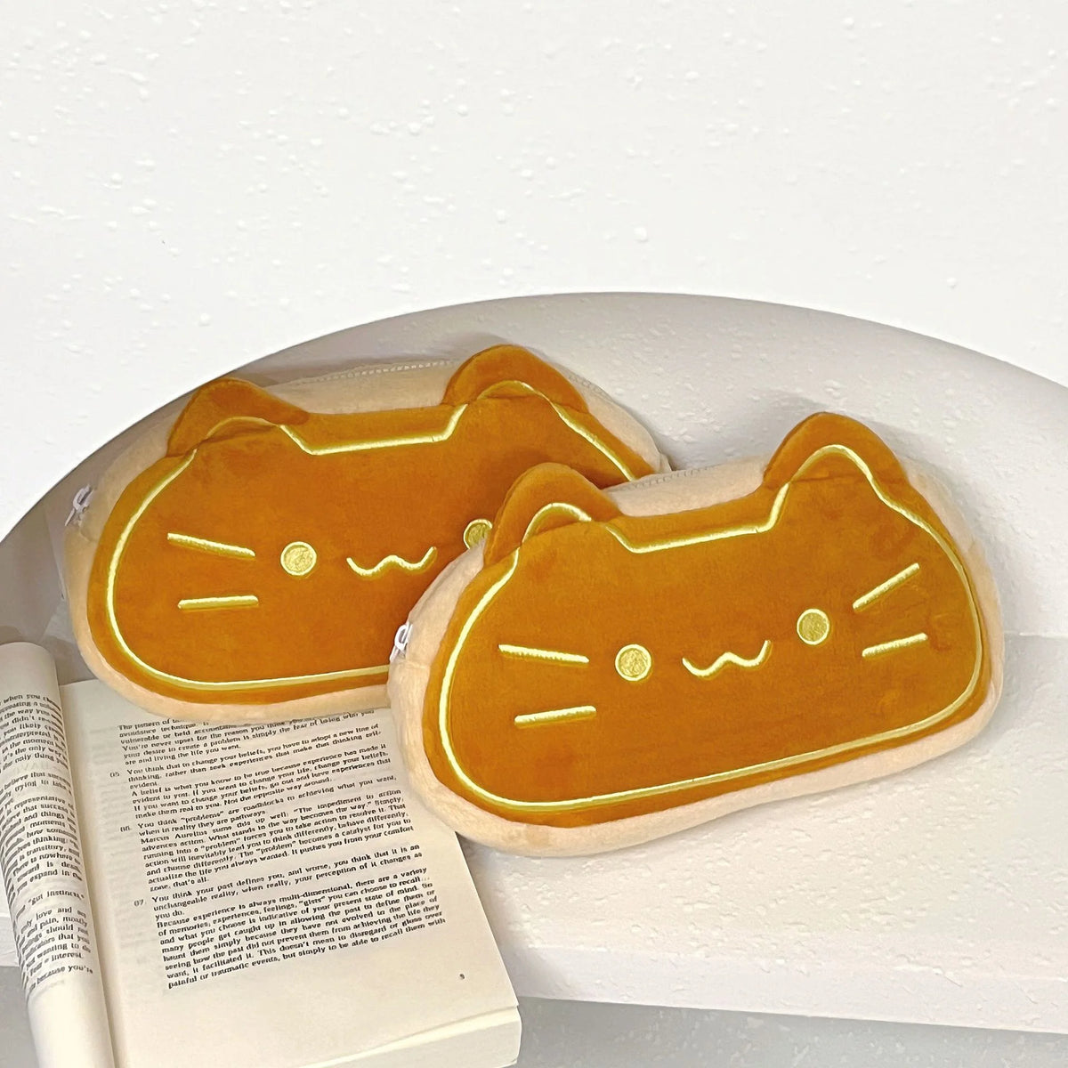 A caramel cat plush pencil case with large capacity sits on a white surface.