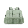 A light sage green waterproof diaper bag with mesh straps and a textured knit bottom.