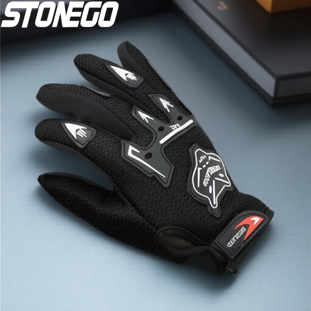 A close-up of black full finger nylon riding gloves with anti-slip grips resting on a gray surface.