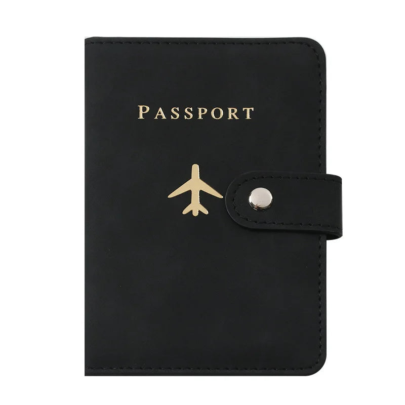 Porte-passeport en cuir noir avec impression dorée et fermeture à pression argentée.