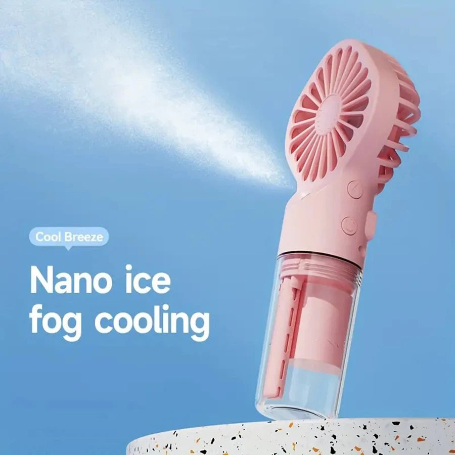 A pink handheld spray fan with a cooling grille is shown against a light blue background.