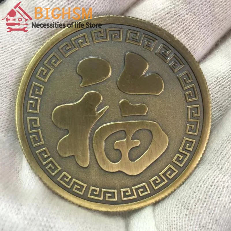 Runder goldener Münze mit stilisiertem chinesischem Koi-Design und geometrischem Rand, in einer Hand gehalten.