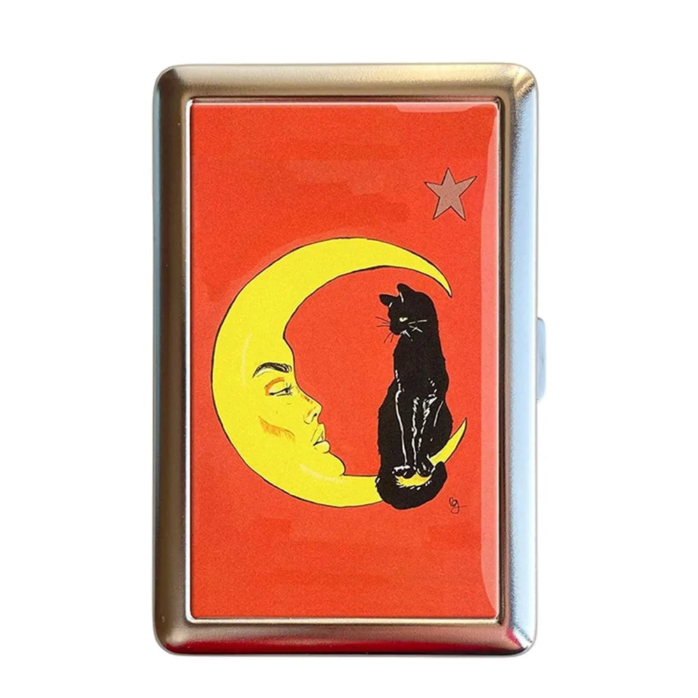 Estuche de tarjeta metálico vintage con silueta de gato contra luna creciente amarilla sobre fondo naranja.