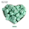 A pile of mint green silicone crown star heart beads for DIY jewelry making
