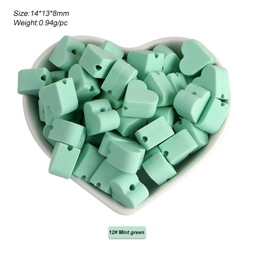 A pile of mint green silicone crown star heart beads for DIY jewelry making