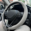A close-up view of a steering wheel with a light gray leather cover installed inside a car.