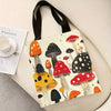 A tote bag featuring a print of various colorful mushrooms on a light background.