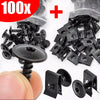 A kit of black self-tapping screws and U-shaped spacers shown next to a hand for scale.