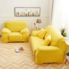 A bright yellow silky soft stretchable sofa cover displayed in a living room setting.