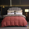 A luxury comforter featuring white goose and duck down with a cotton cover displayed on a bed.