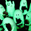 A collection of glowing green ghost figurines shaped like cats in a blind box display.